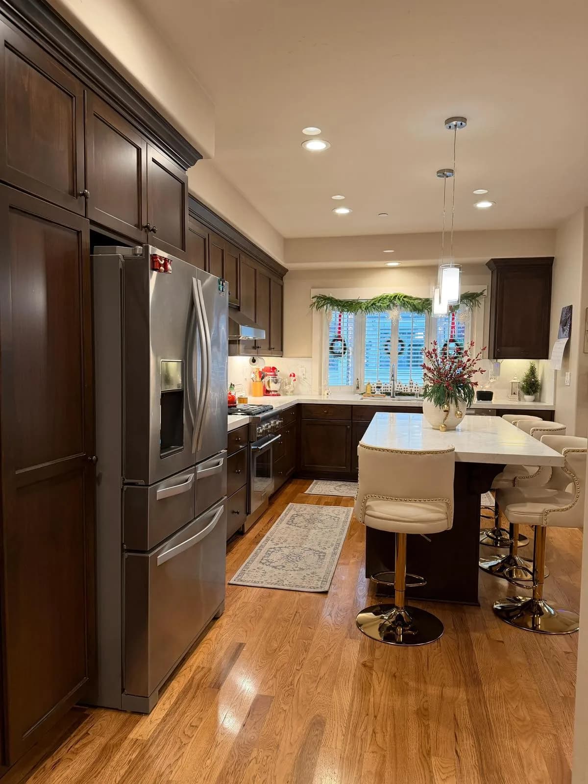 Espresso kitchen cabinets with stainless French-door refrigerator and quartz island